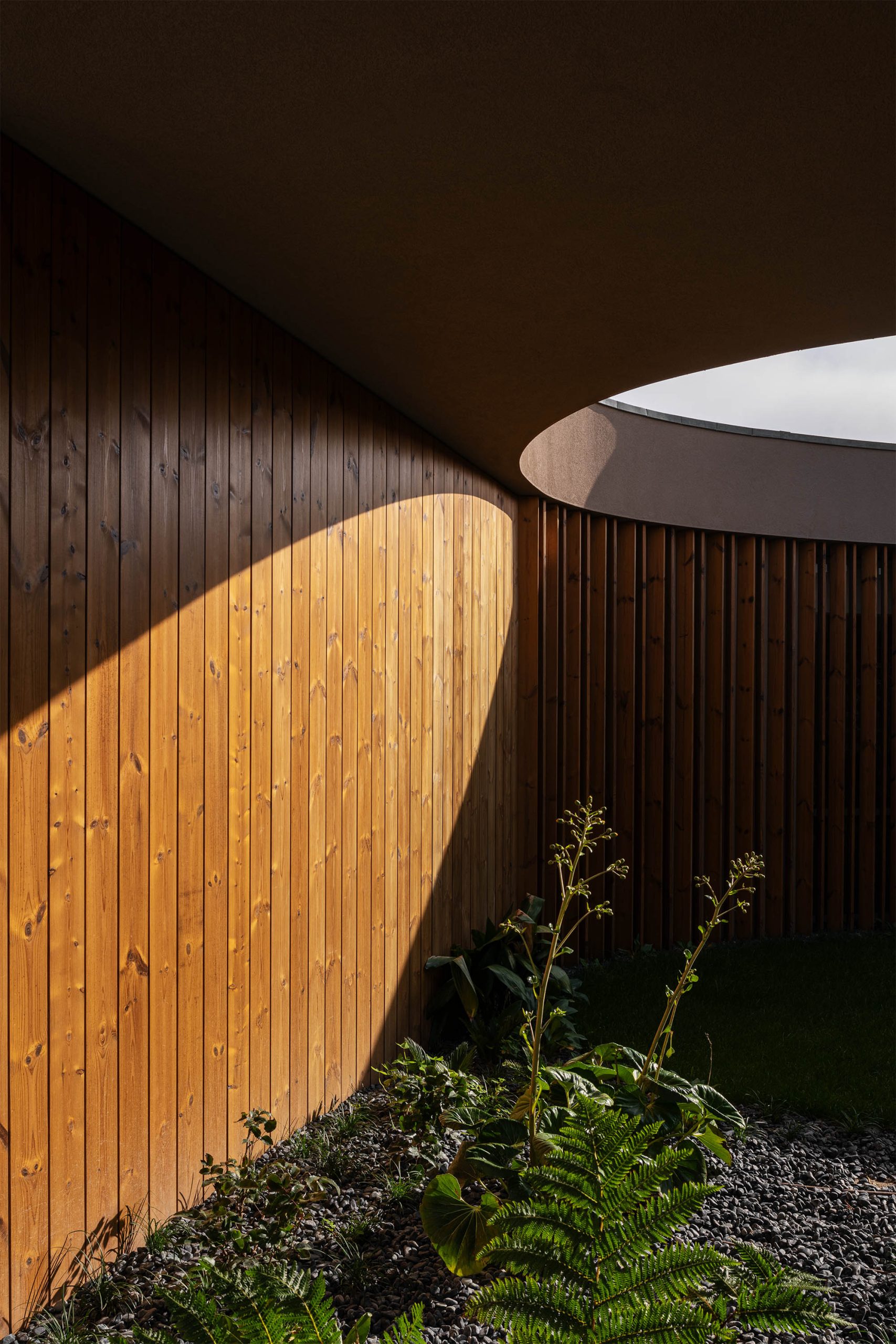 Jardim central enquadrado por volumes arquitetónicos contemporâneos