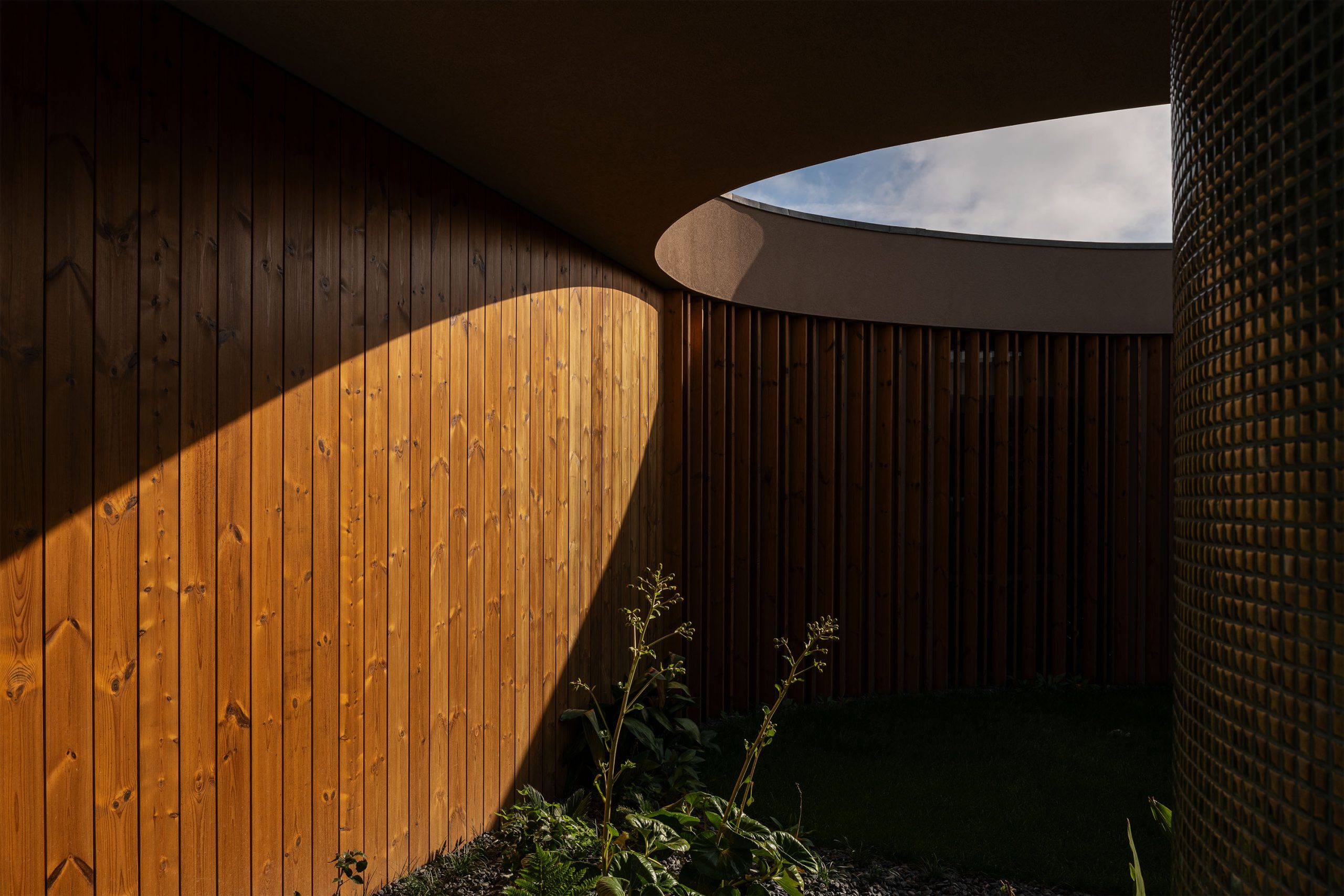 Jardim central enquadrado por volumes arquitetónicos contemporâneos