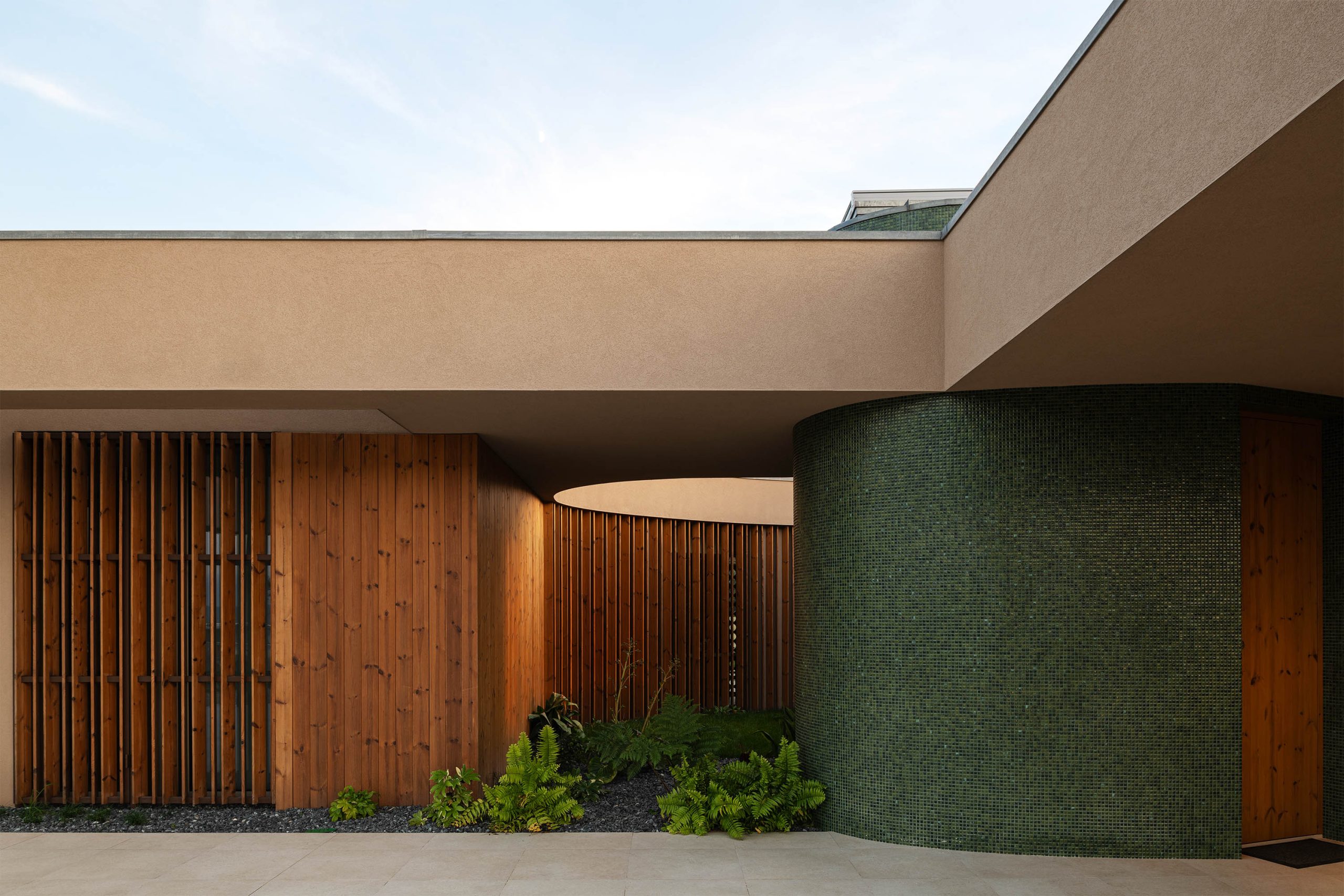 Jardim central enquadrado por volumes arquitetónicos contemporâneos