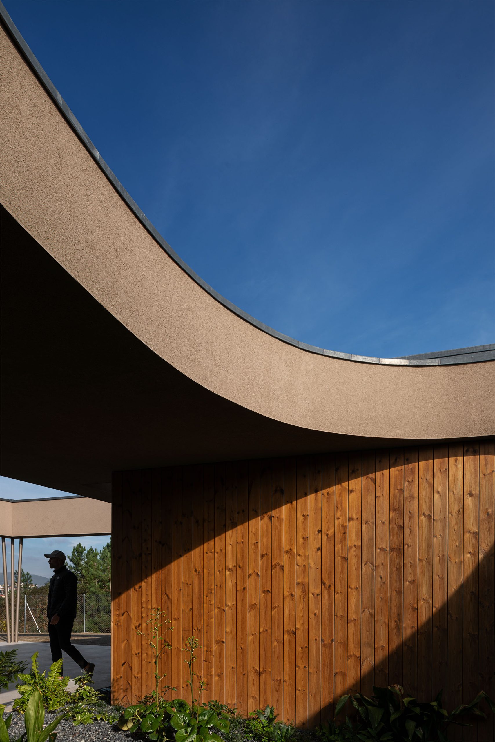 Jardim central enquadrado por volumes arquitetónicos contemporâneos