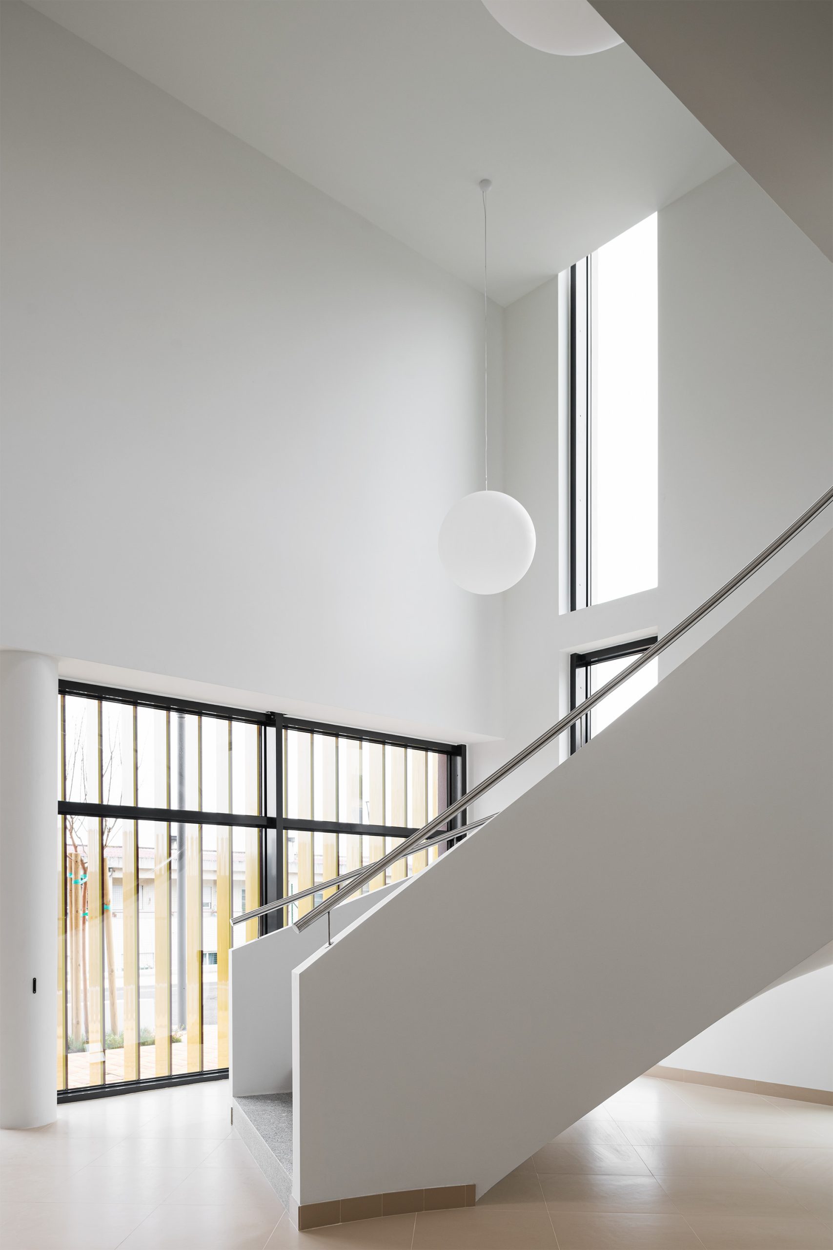 Luminárias esféricas suspensas em espaço branco com geometria angular