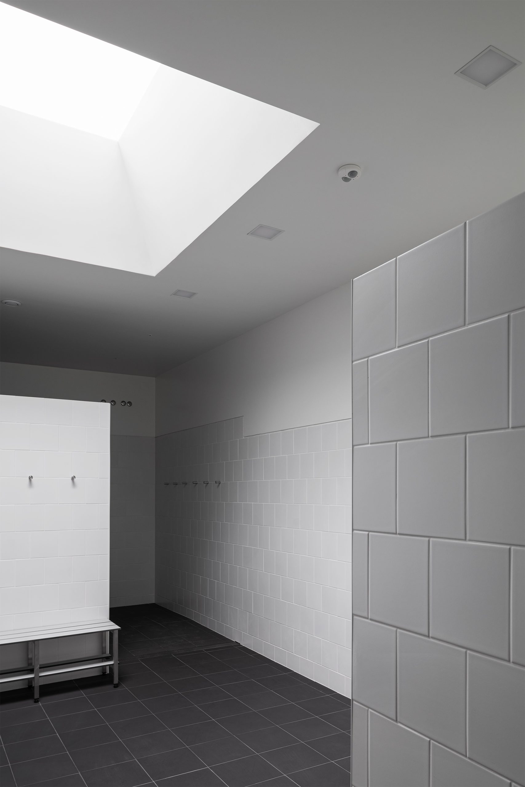 WC contemporâneo com luz indireta e revestimento cerâmico claro