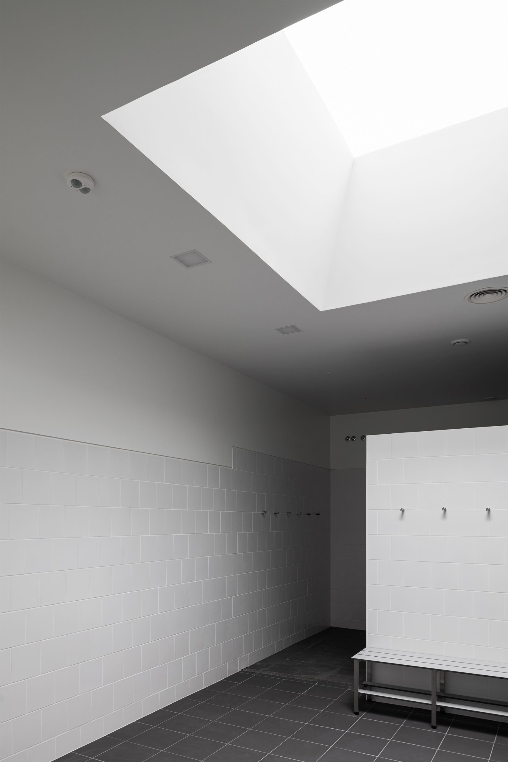 WC contemporâneo com luz indireta e revestimento cerâmico claro