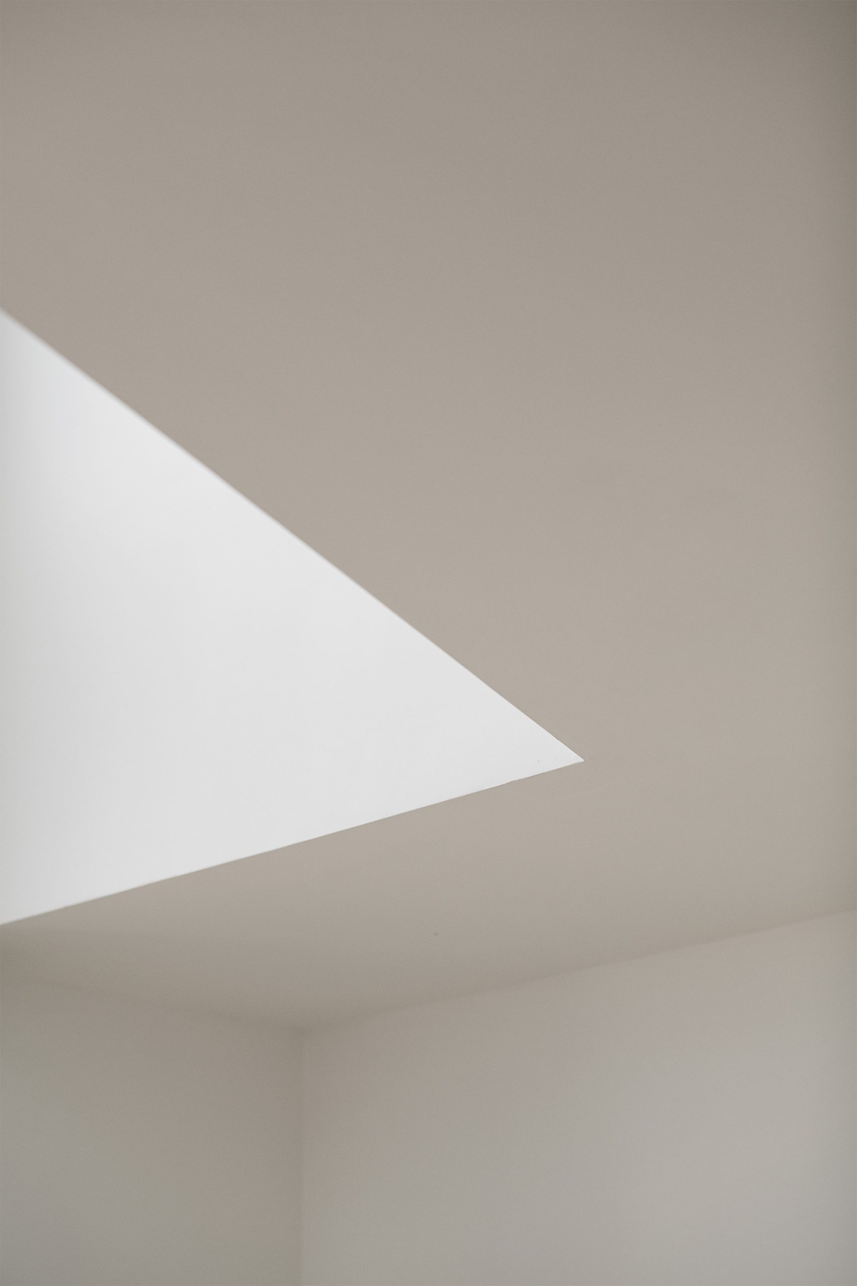 Luminárias esféricas suspensas em espaço branco com geometria angular