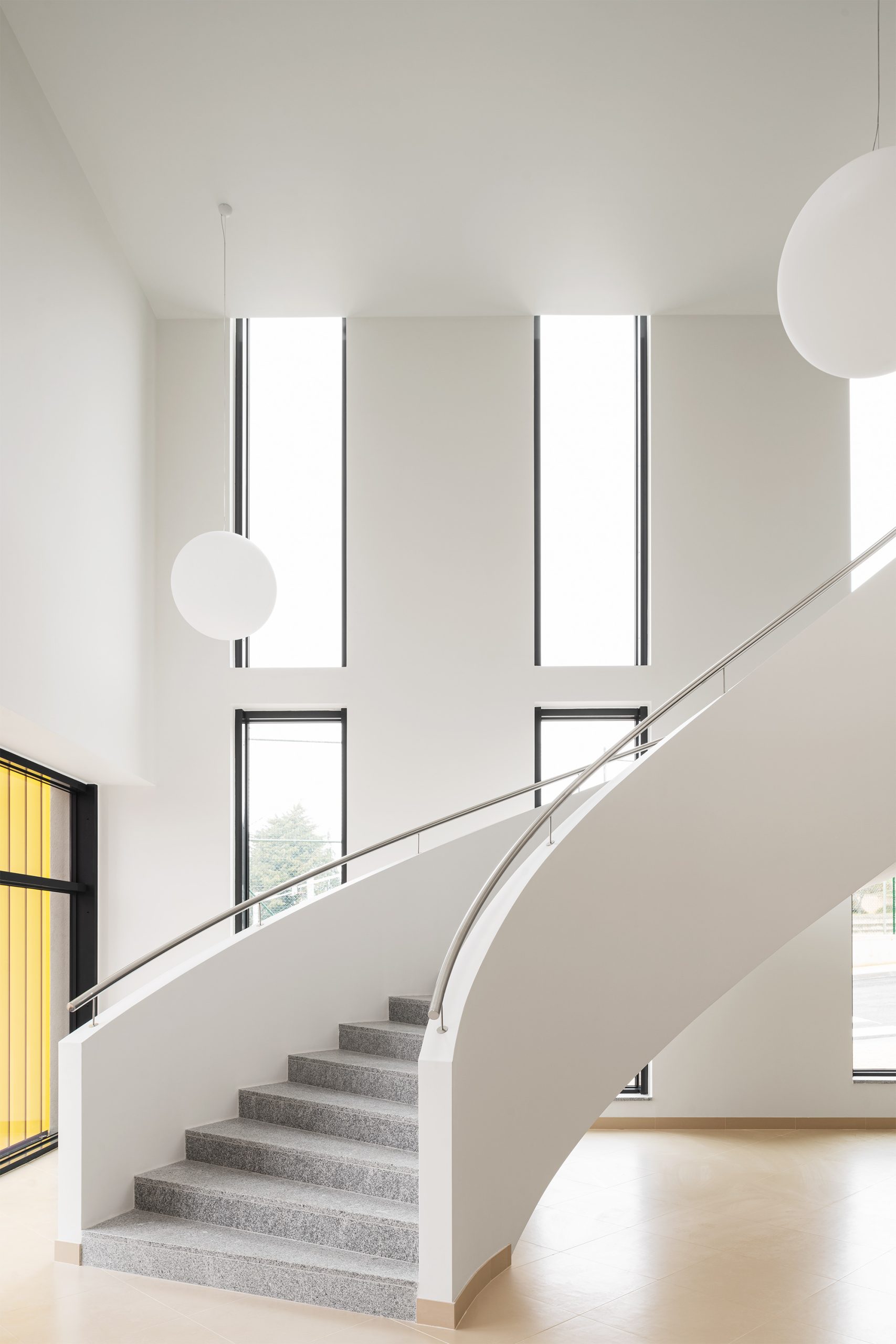 Luminárias esféricas suspensas em espaço branco com geometria angular