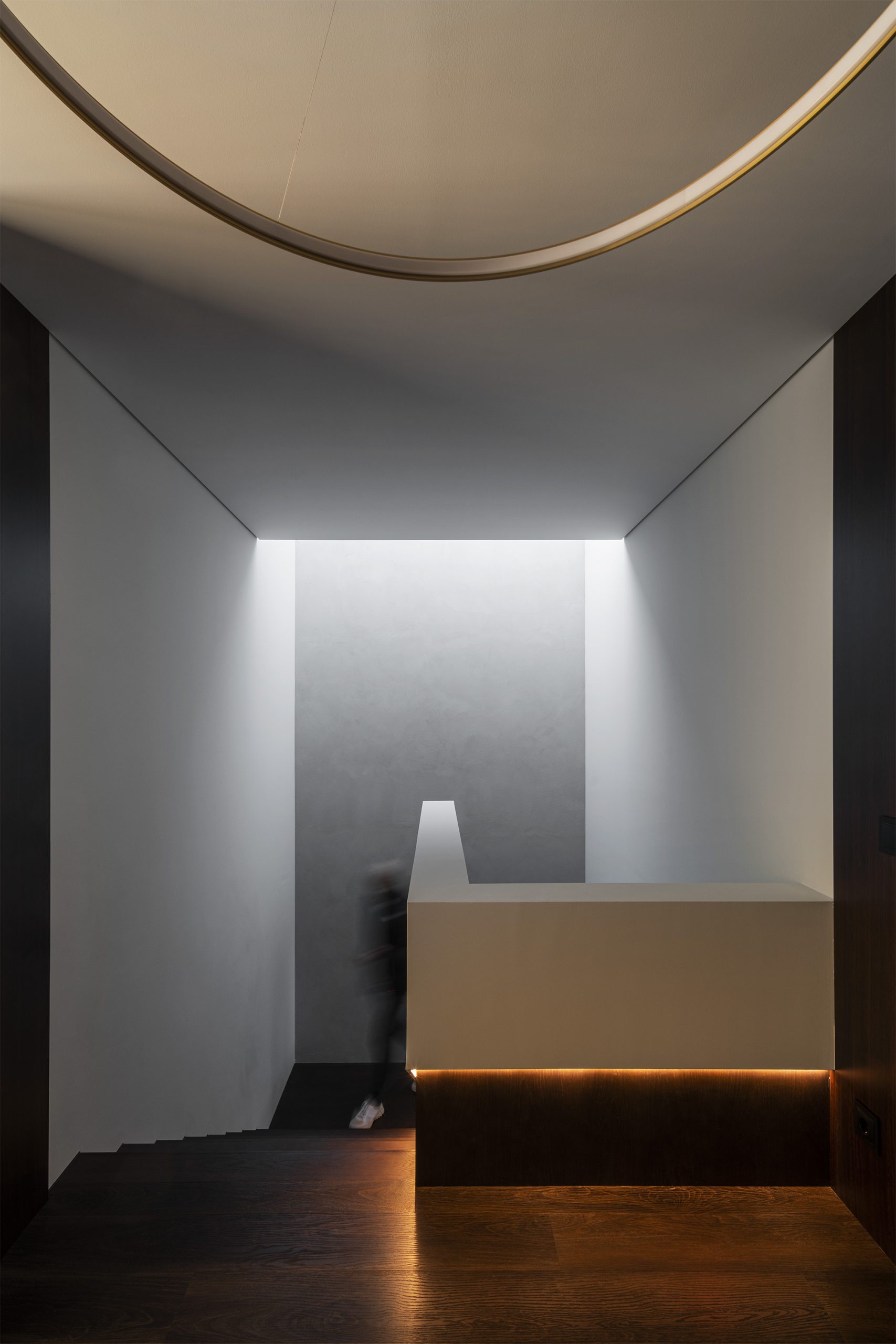 Escada interior com luz indireta e pavimento em madeira escura