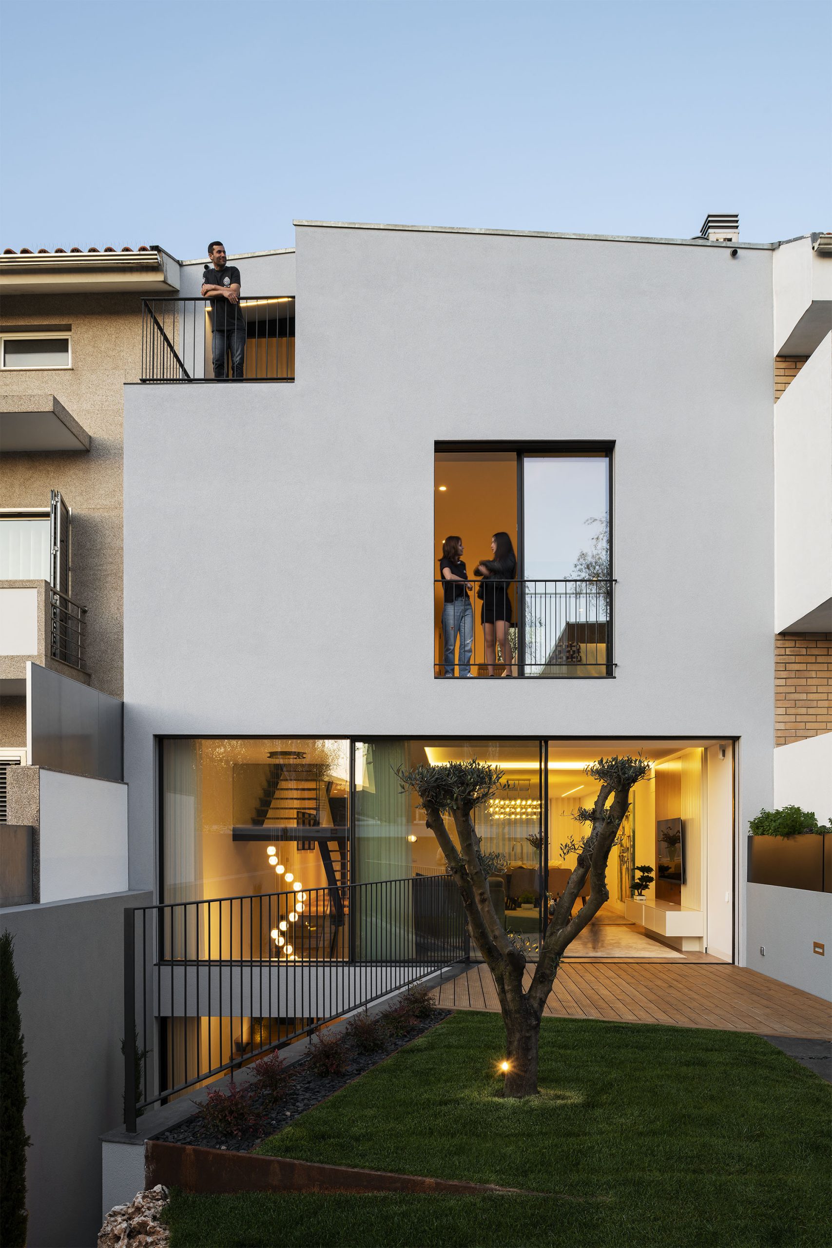 Fachada lateral com jogo de volumes e textura de revestimentos claros