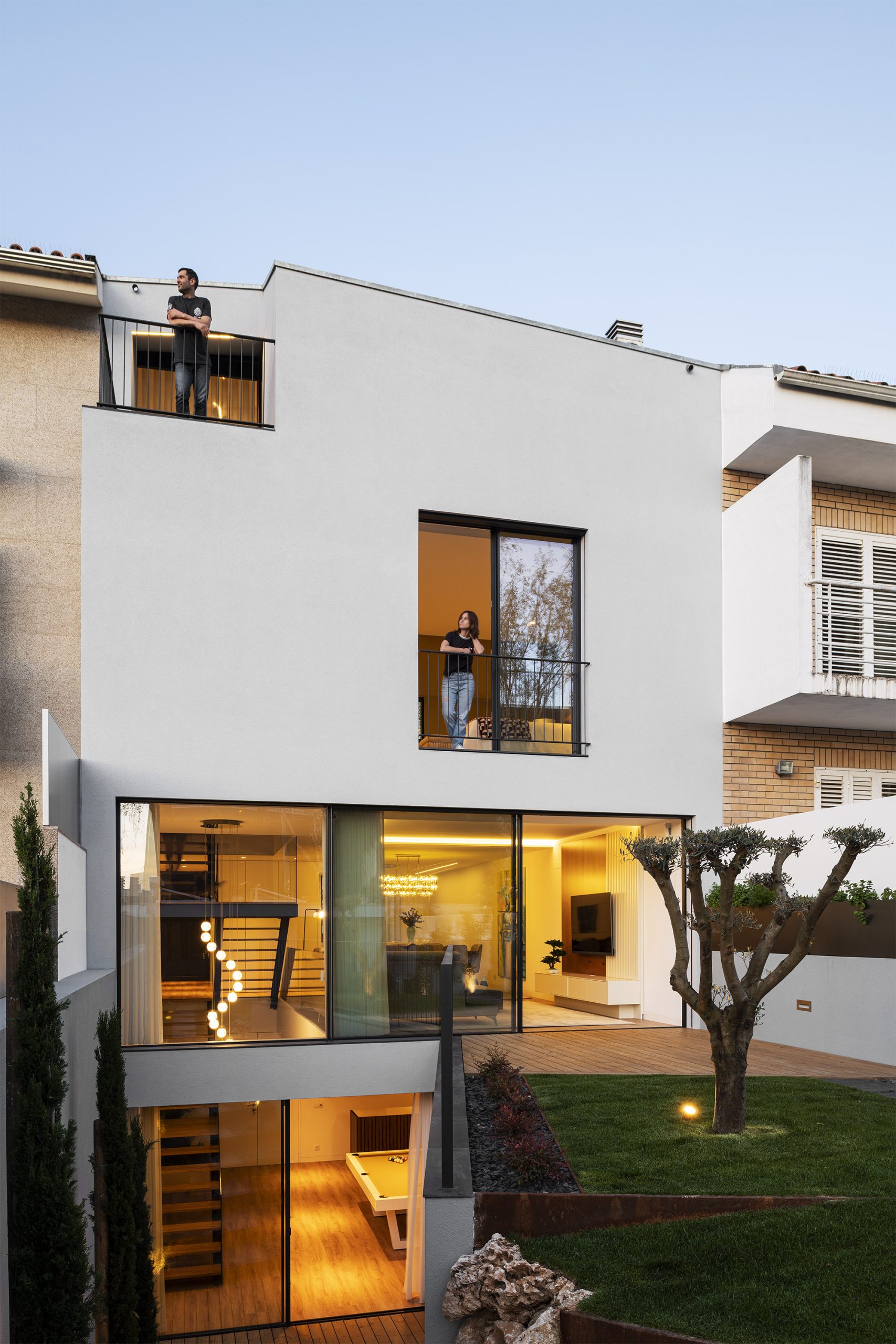 Fachada lateral com jogo de volumes e textura de revestimentos claros