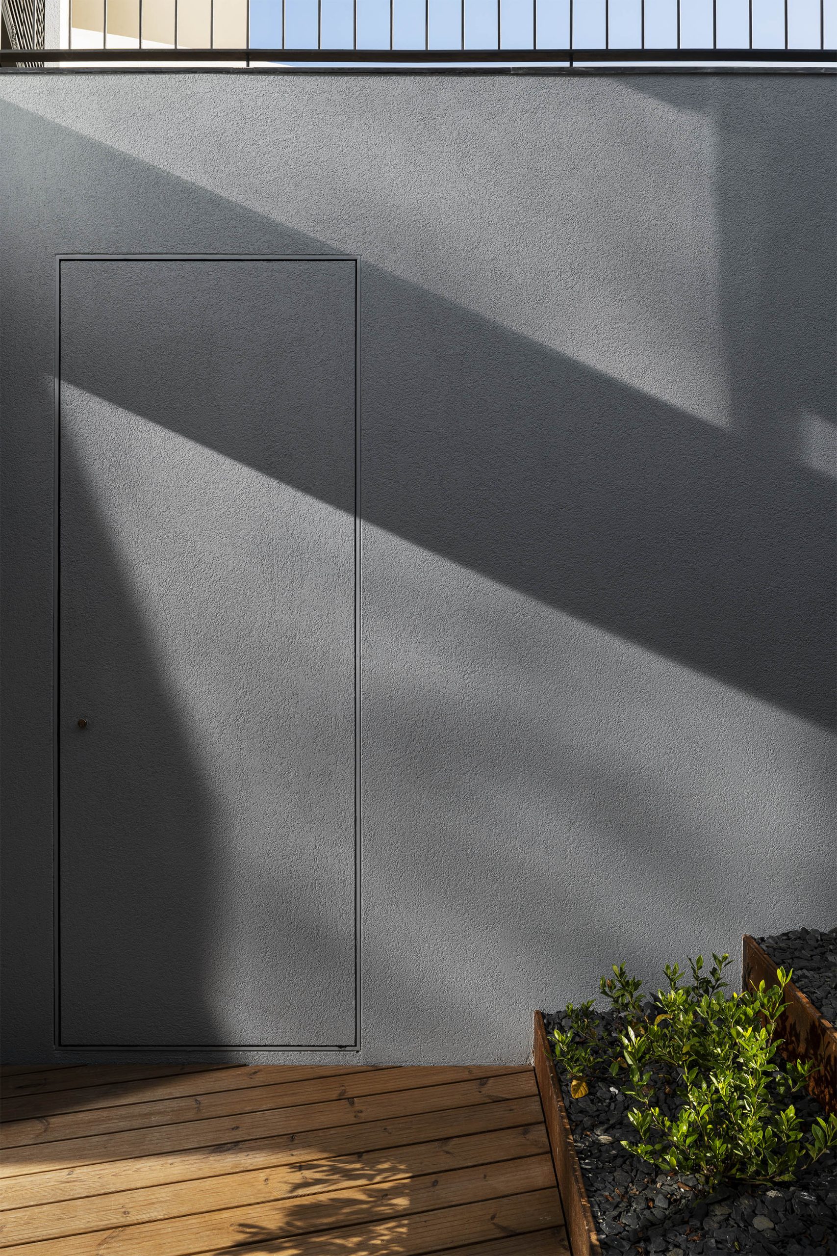 Detalhe de escada em madeira com sombra projetada no plano branco