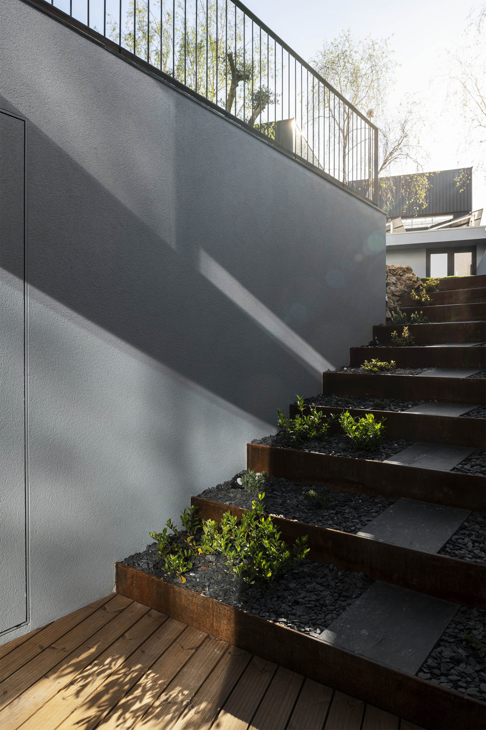 Detalhe de escada em madeira com sombra projetada no plano branco