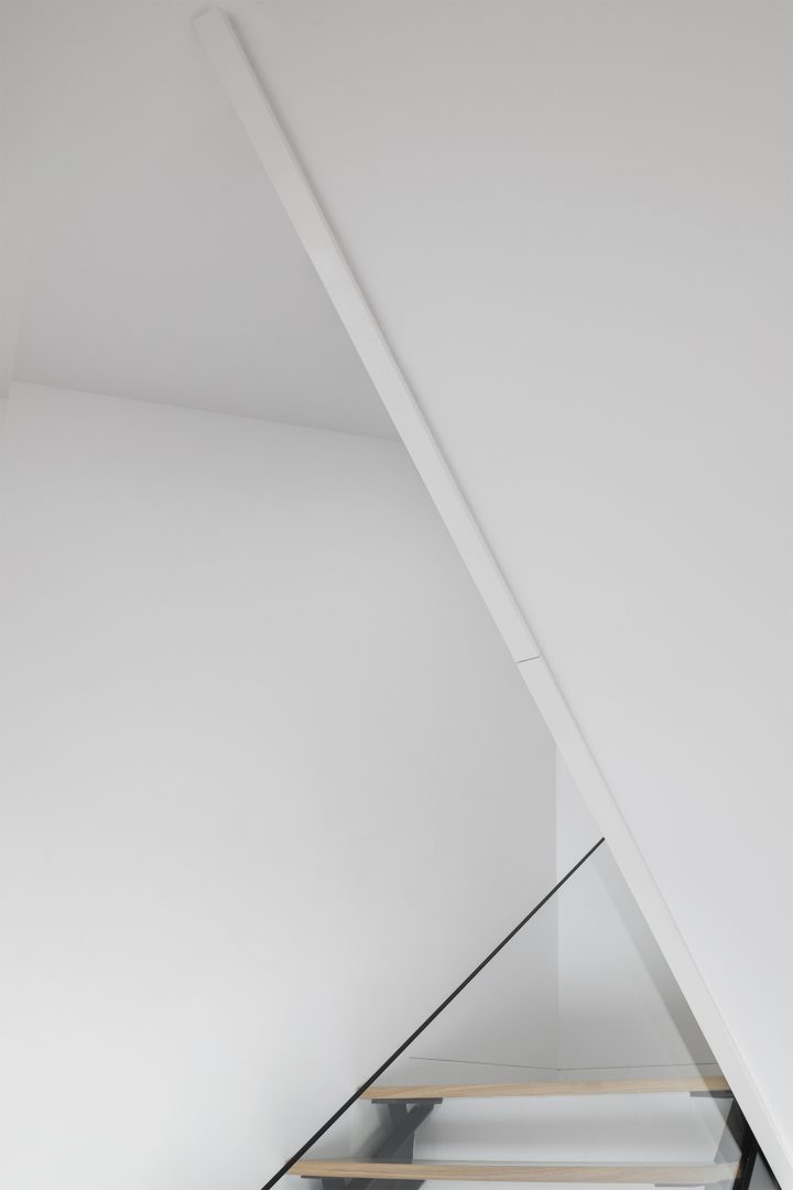 Detalhe de escada em madeira com sombra projetada no plano branco