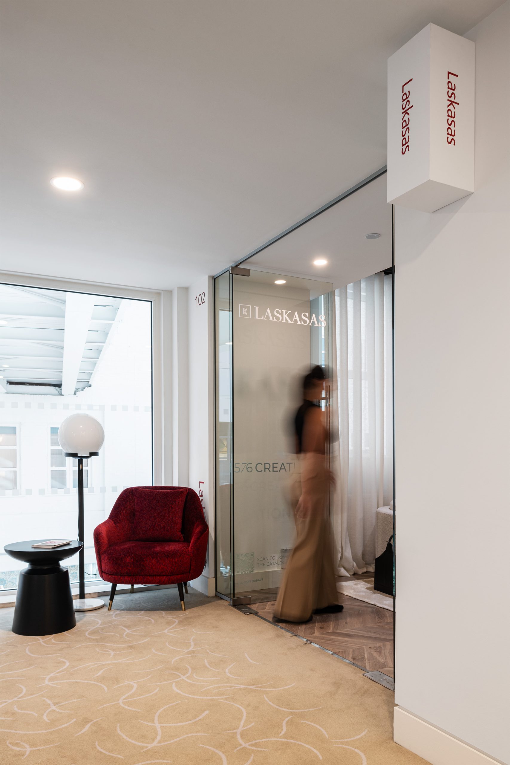 Vista da loja da Laskasas no Design Centre em Londres, com foco em poltrona vermelha e iluminação natural.