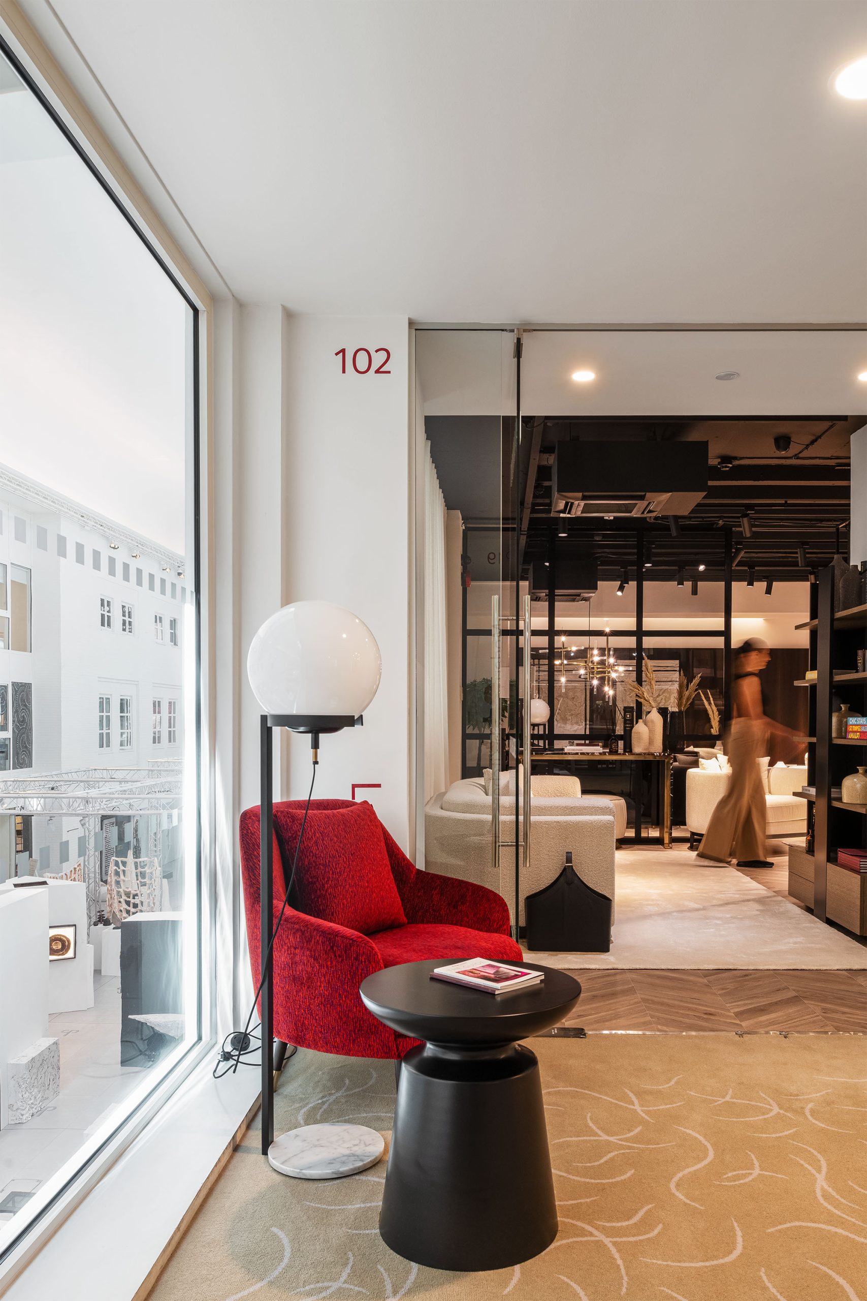 Vista da loja da Laskasas no Design Centre em Londres, com foco em poltrona vermelha e iluminação natural.