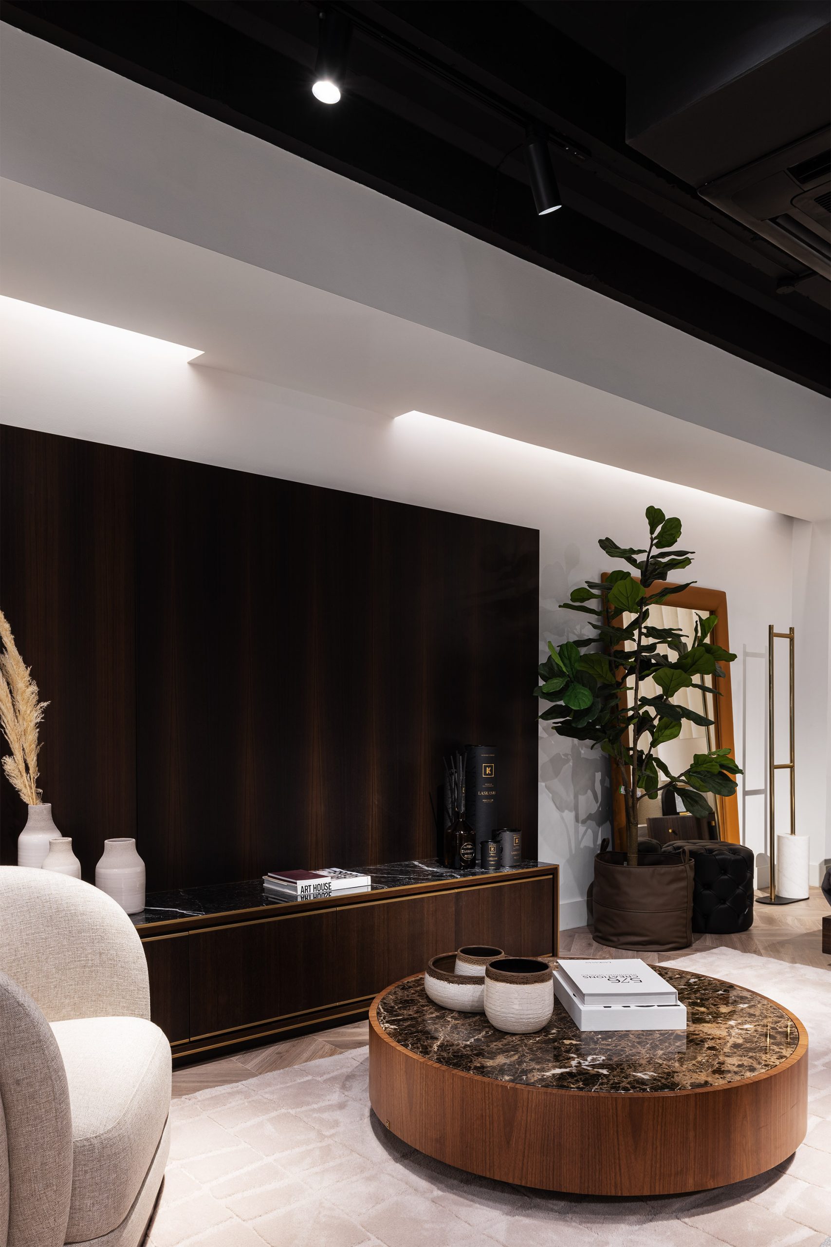 Detalhe da decoração interior com mesa de centro em mármore e elementos decorativos na loja Laskasas