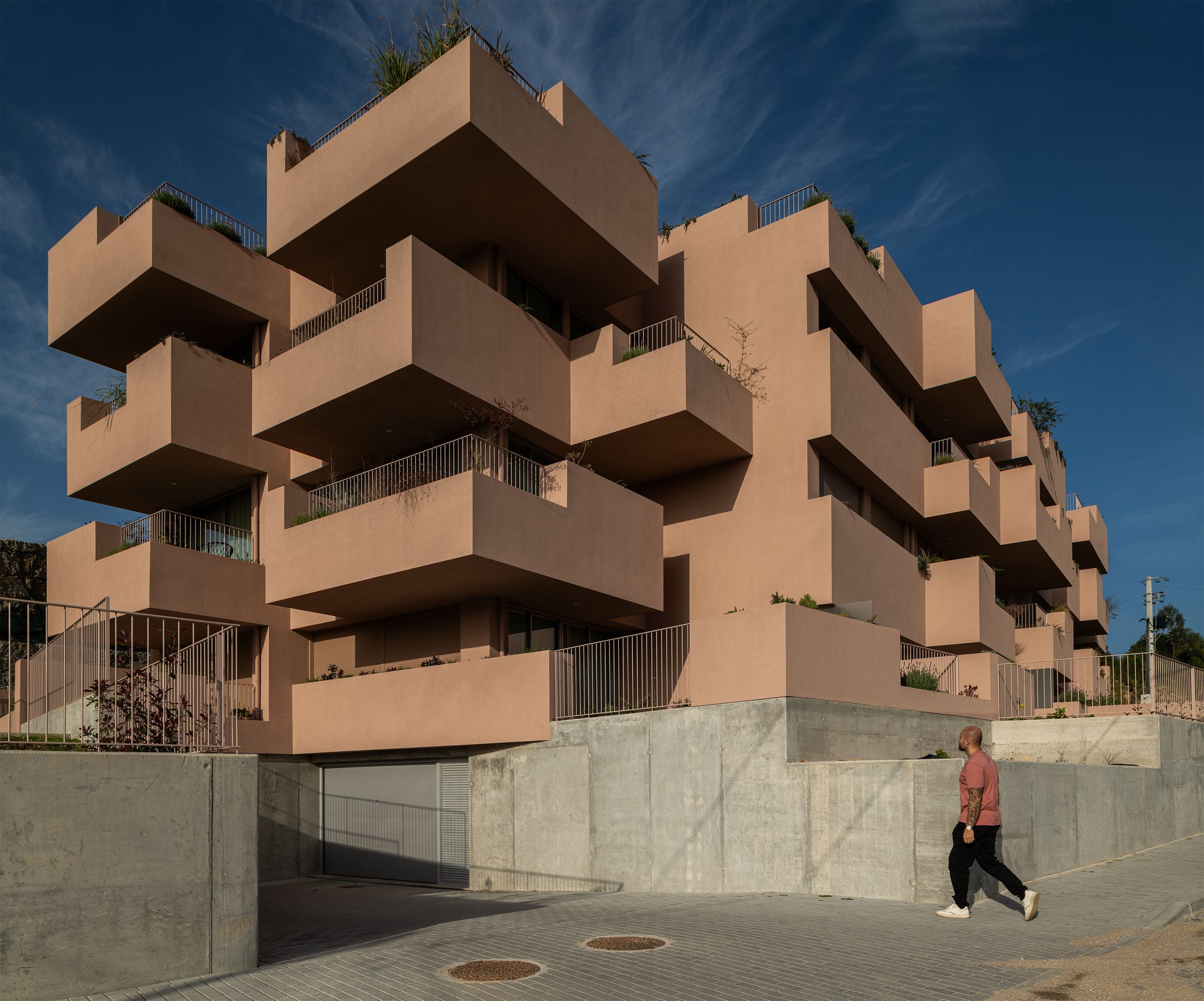 Fachada principal da habitação multifamiliar CFDS Architecture em Penafiel com planos alternados e cor laranja.