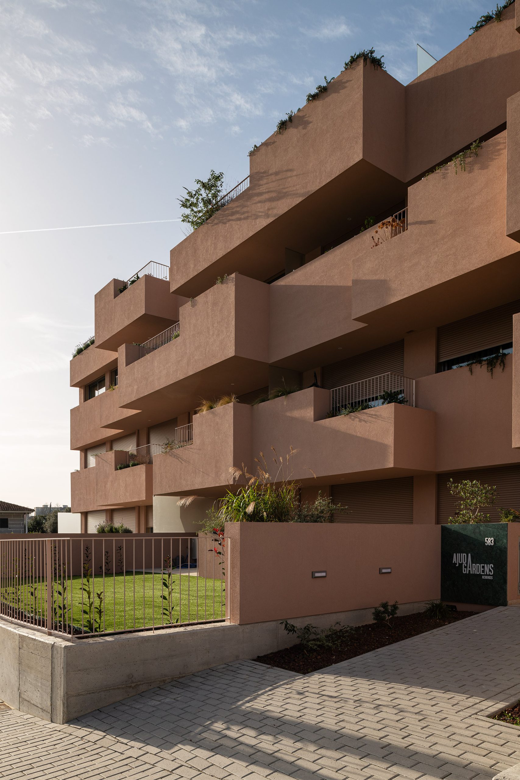 Fachada principal da habitação multifamiliar CFDS Architecture em Penafiel com planos alternados e cor laranja.