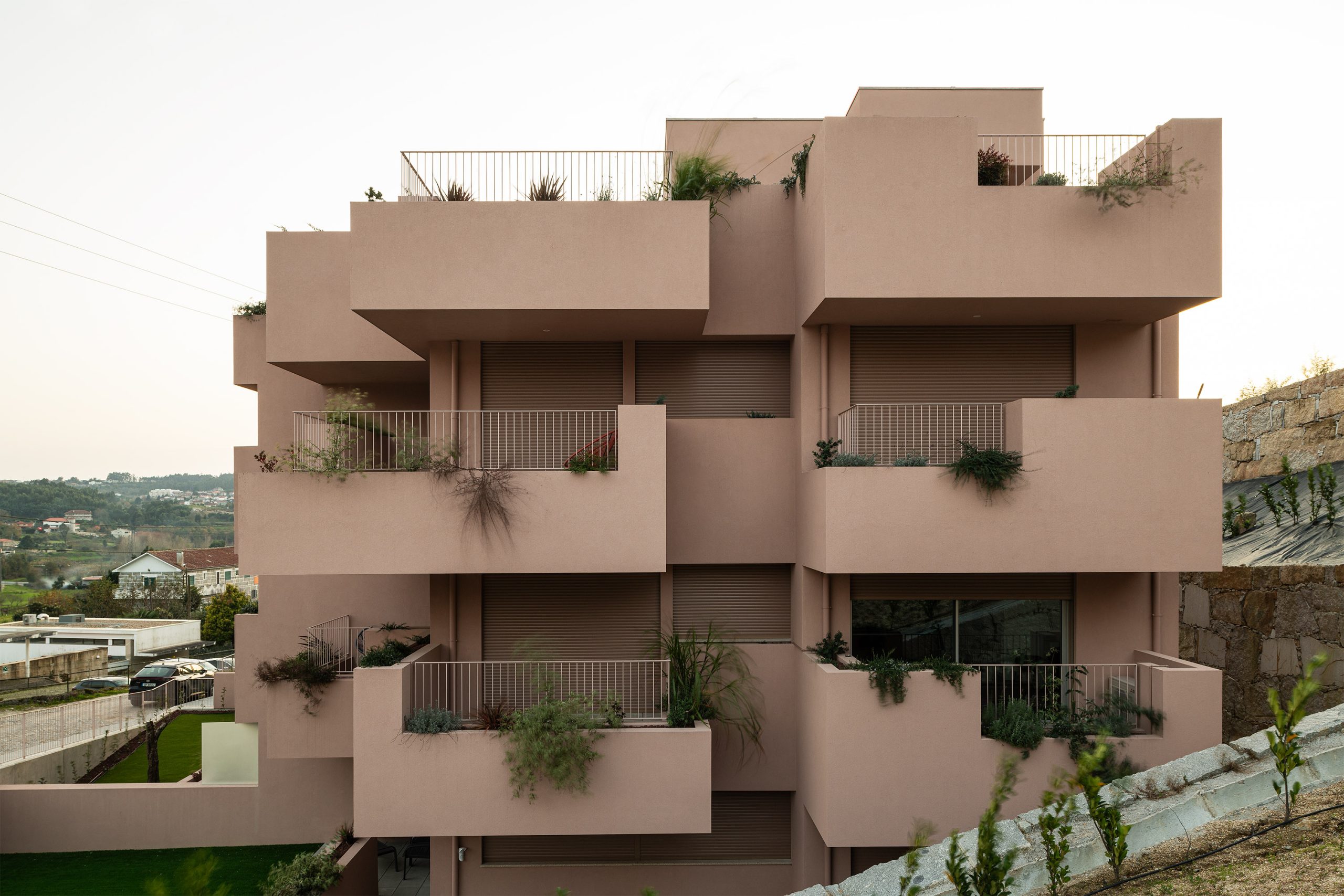 Fachada principal da habitação multifamiliar CFDS Architecture em Penafiel com planos alternados e cor laranja.