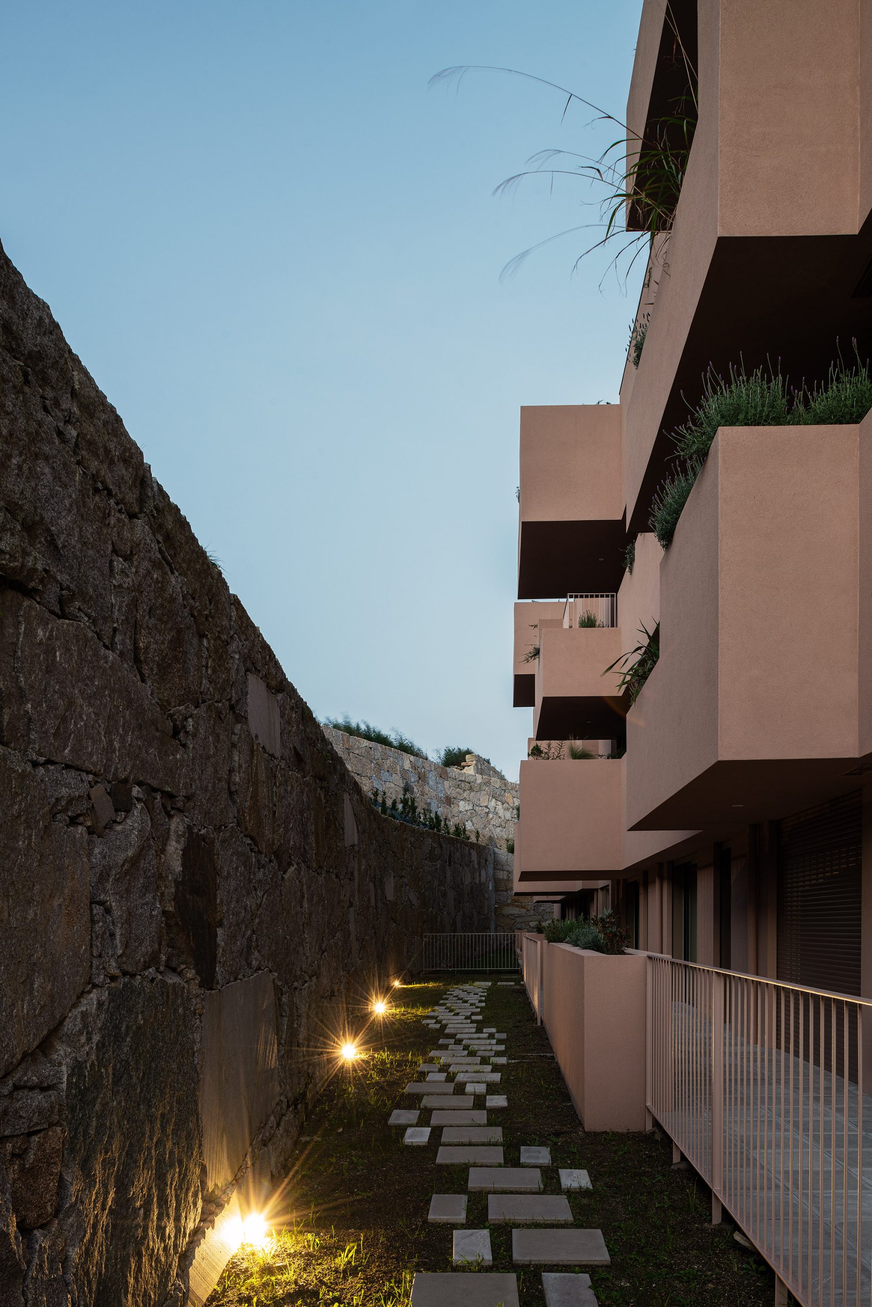 Fachada principal da habitação multifamiliar CFDS Architecture em Penafiel com planos alternados e cor laranja.