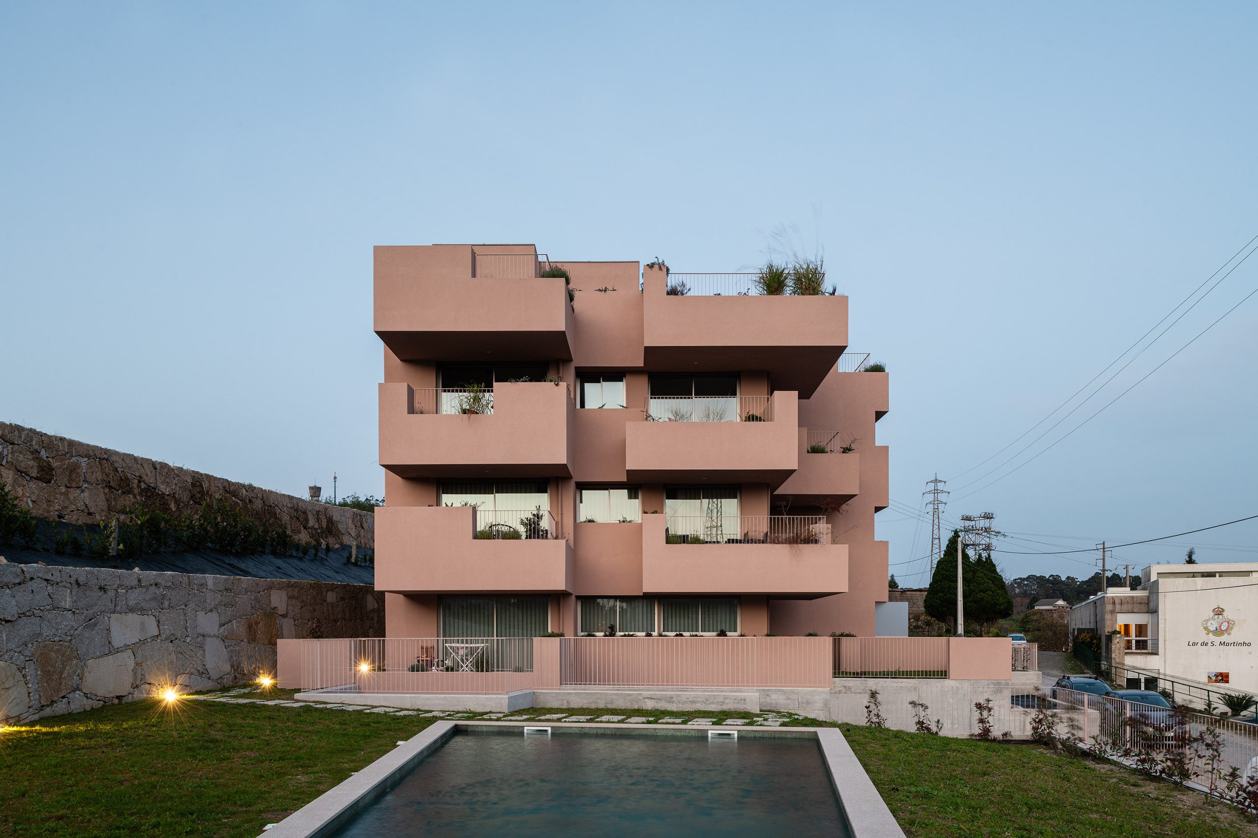 Fachada principal da habitação multifamiliar CFDS Architecture em Penafiel com planos alternados e cor laranja.