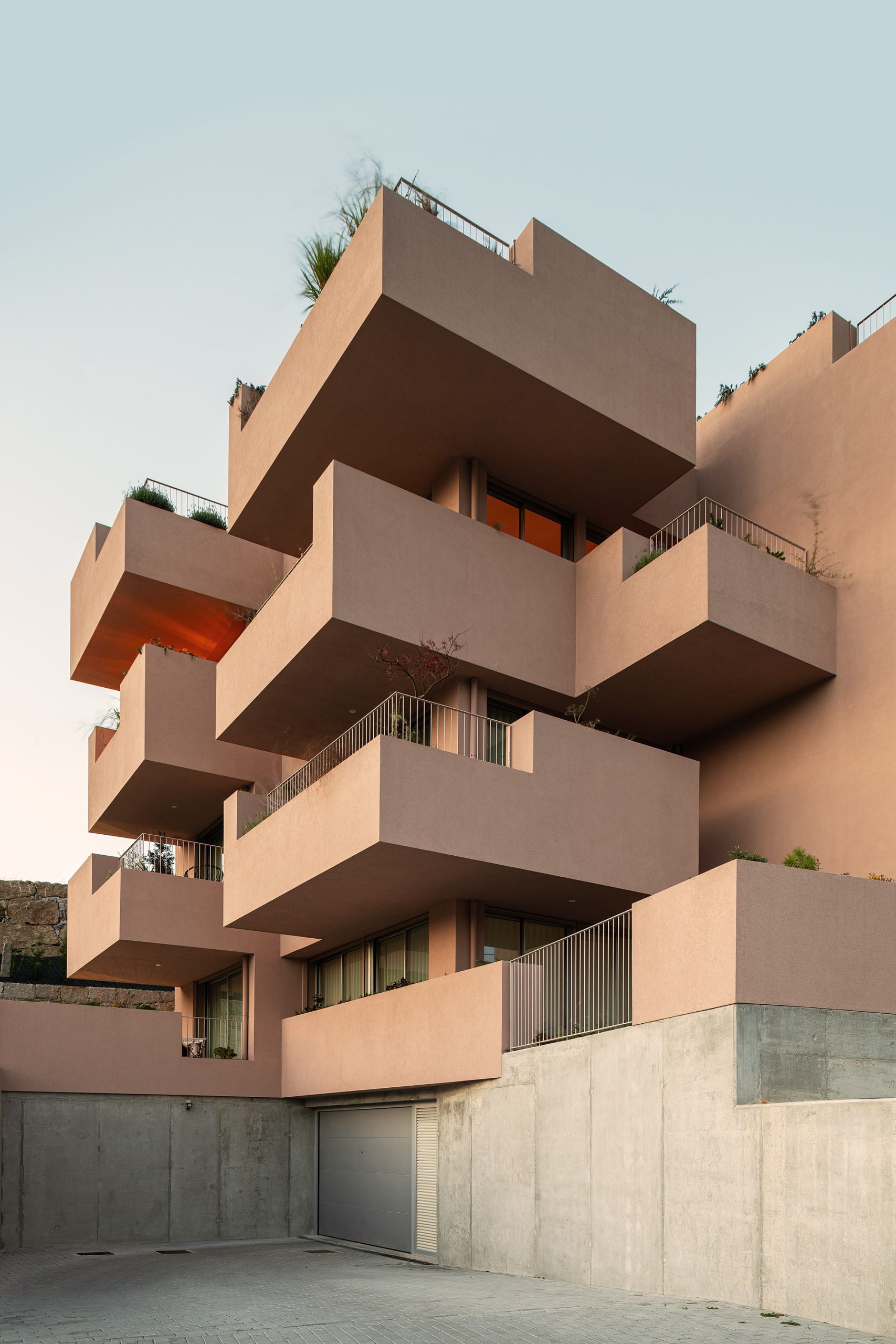 Fachada principal da habitação multifamiliar CFDS Architecture em Penafiel com planos alternados e cor laranja.