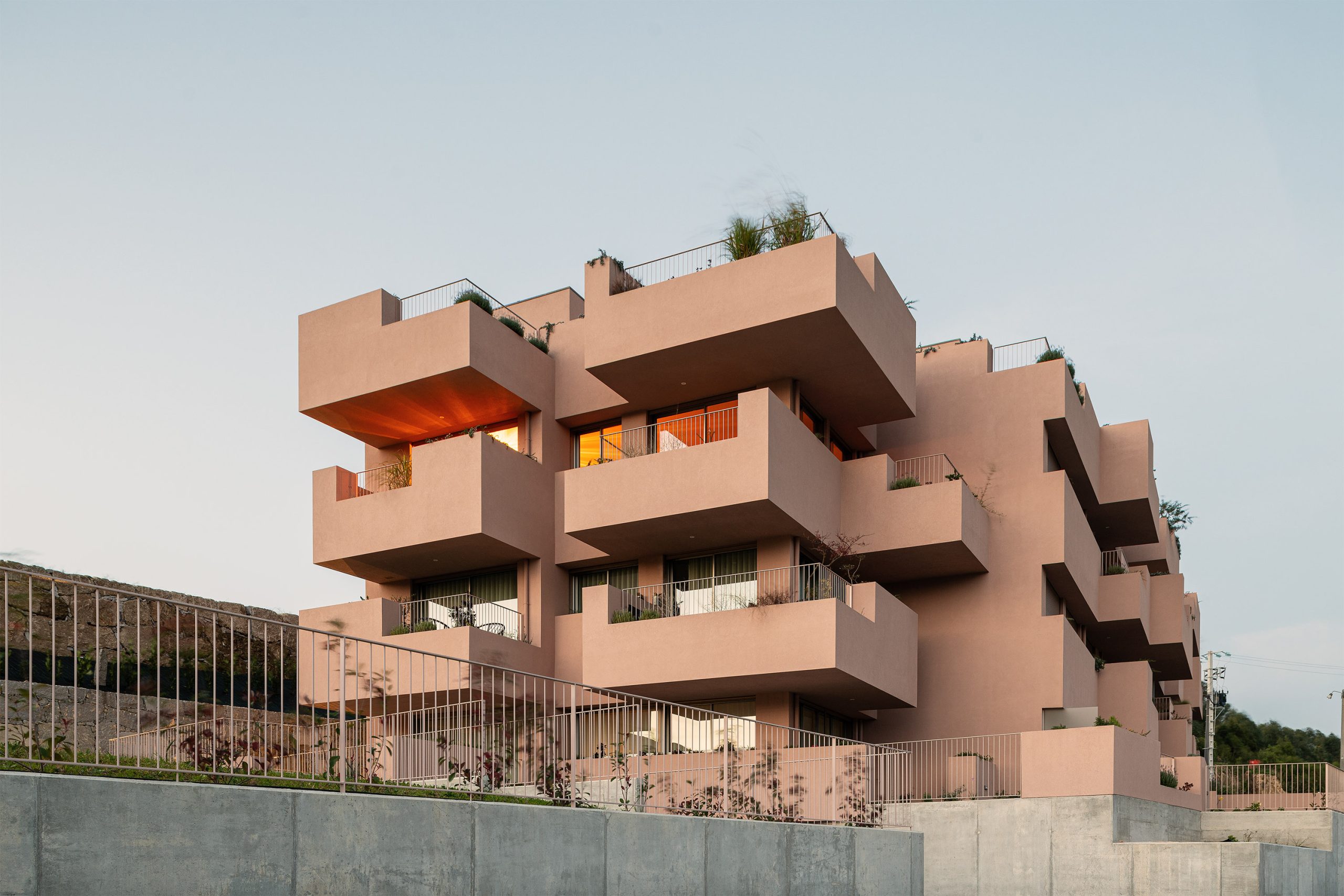 Fachada principal da habitação multifamiliar CFDS Architecture em Penafiel com planos alternados e cor laranja.