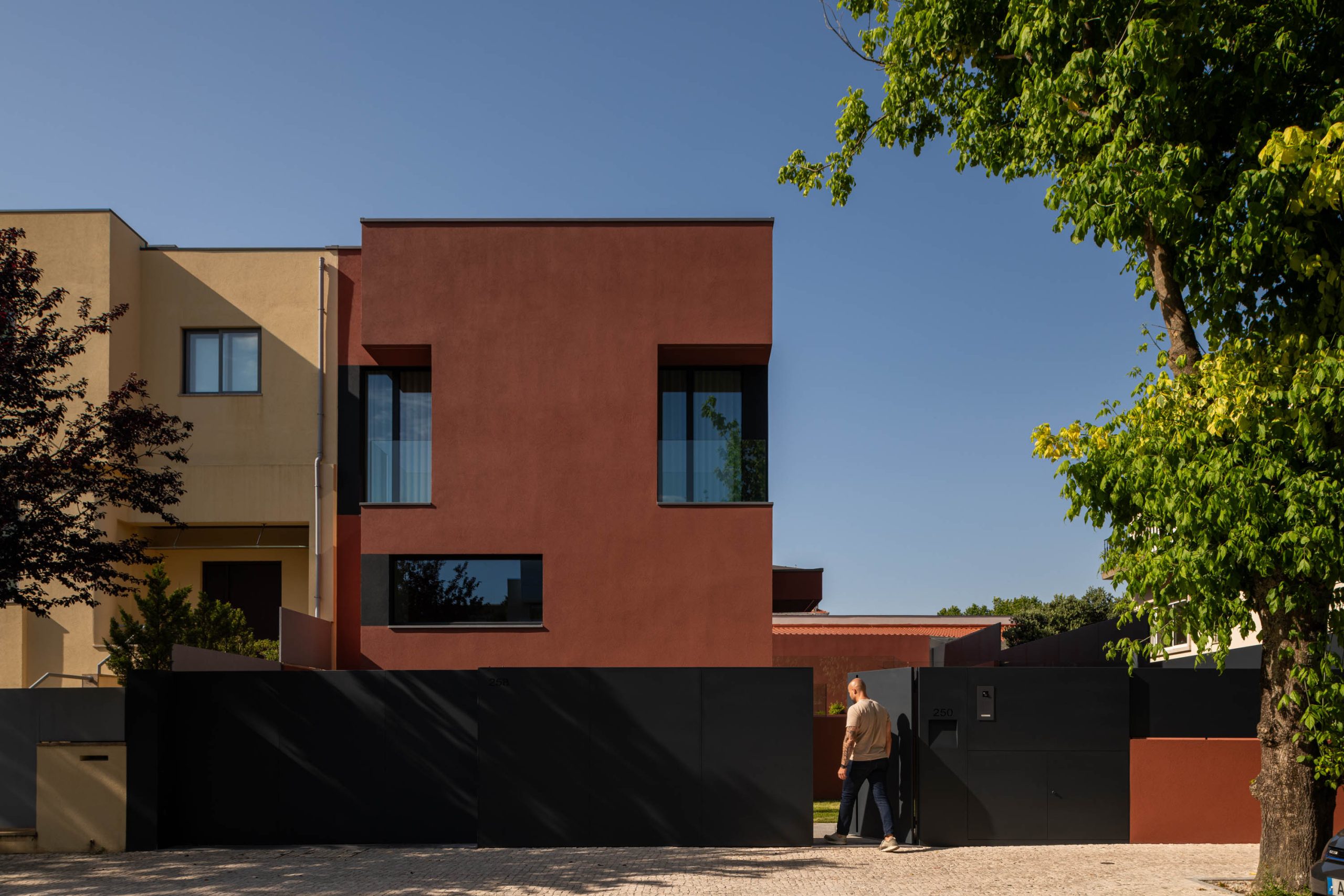 Fachada em tom vermelho/bordéus de moradia unifamiliar no Porto, projeto Utopia Arquitetura