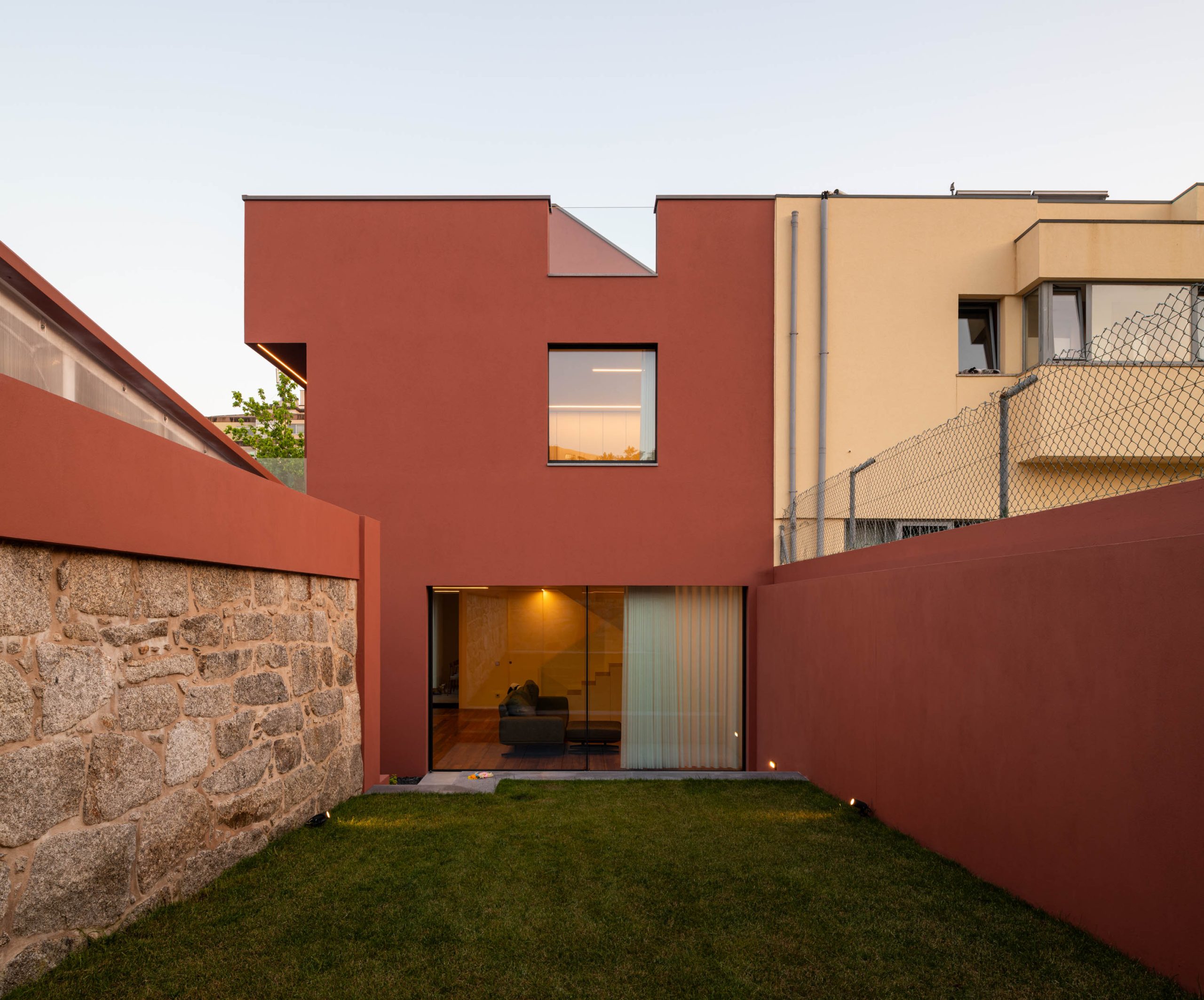 Fachada em tom vermelho/bordéus de moradia unifamiliar no Porto, projeto Utopia Arquitetura