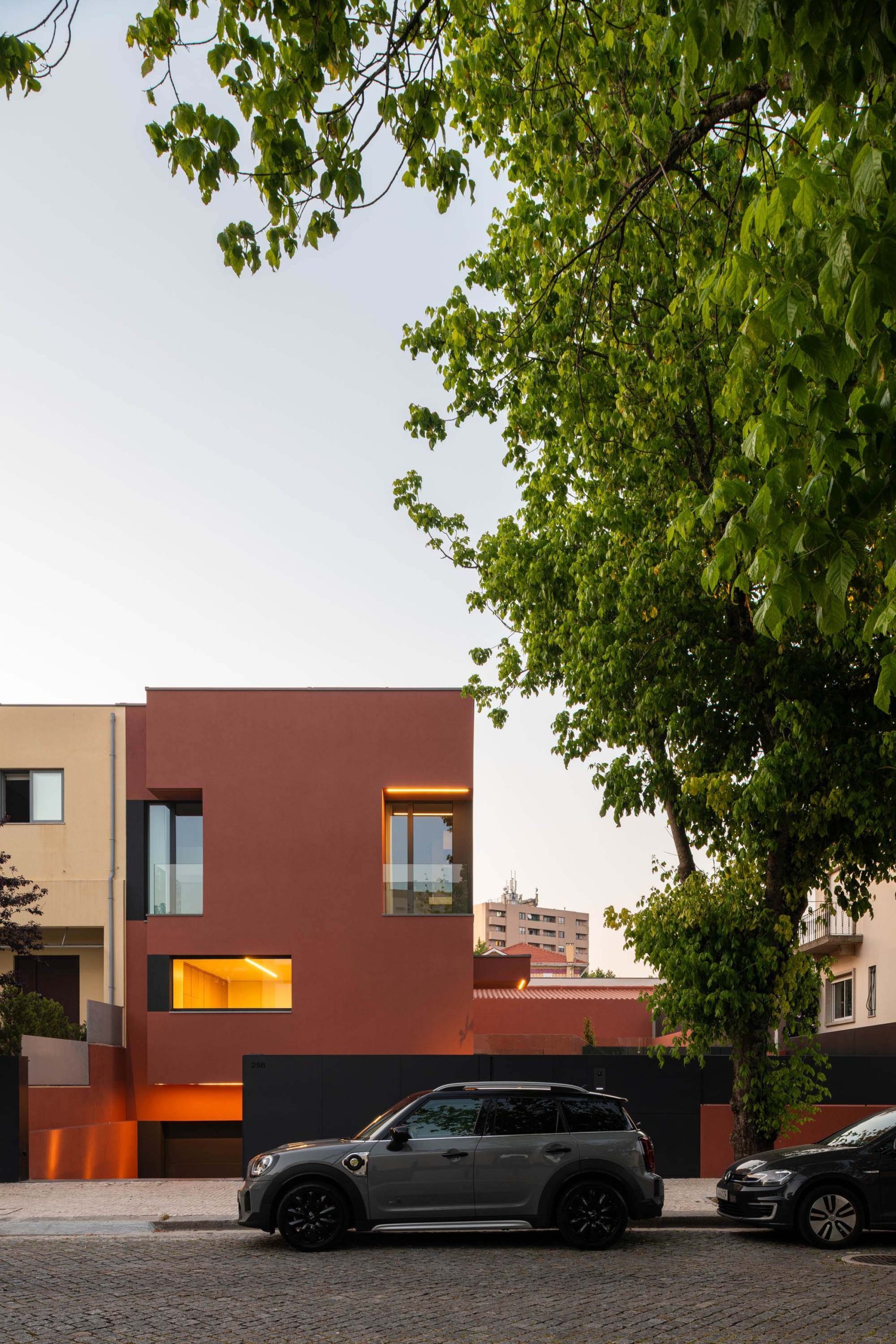 Fachada em tom vermelho/bordéus de moradia unifamiliar no Porto, projeto Utopia Arquitetura